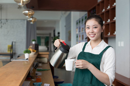 年轻漂亮的女人在咖啡馆工作