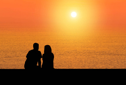 浪漫的情侣坐人孤身后视放松看夕阳