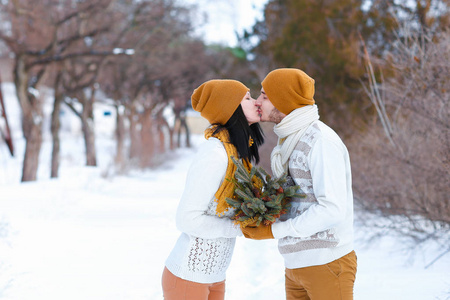 对年轻的夫妇微笑和亲吻到相机在冬天的肖像