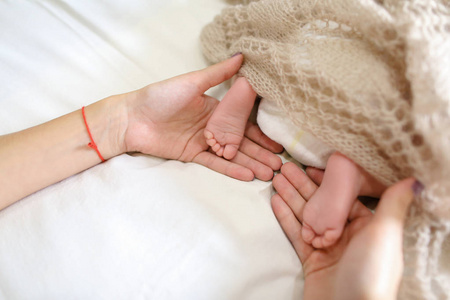 妈妈抱着刚出生的婴儿，手小脚覆盖编系列