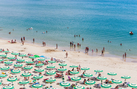 黑海岸边，蓝色清澈的水，海滩沙子 遮阳伞和日光浴浴床。Albena 保加利亚