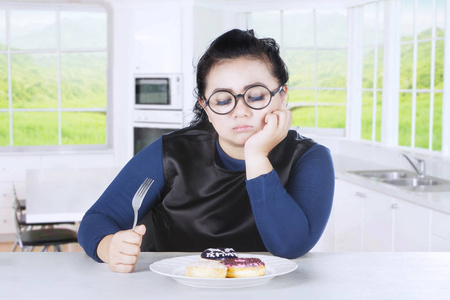 肥胖女性感觉伙食与甜甜圈图片