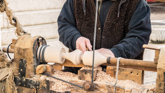 一个工匠雕刻一块木头用手动车床