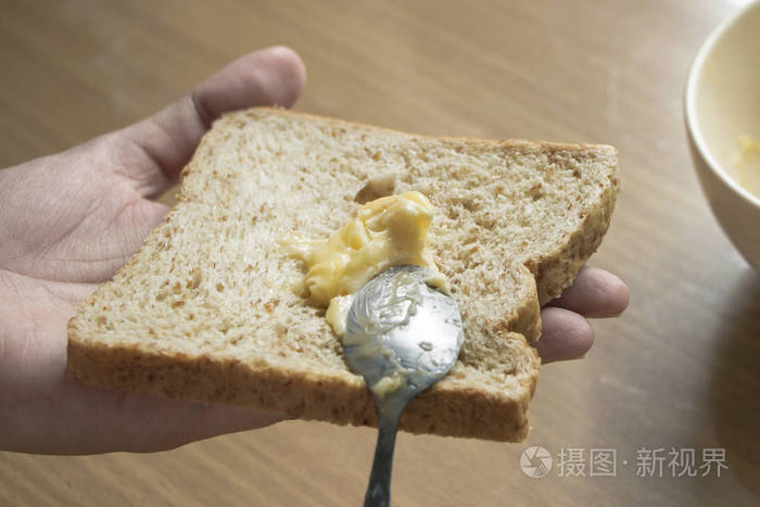 用勺子把大蒜黄油涂在面包上