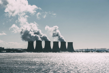 冷却塔的核电站或核发电厂与浓浓的烟雾。暗色调的图像