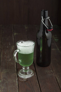 绿色啤酒瓶在深色背景上用玻璃