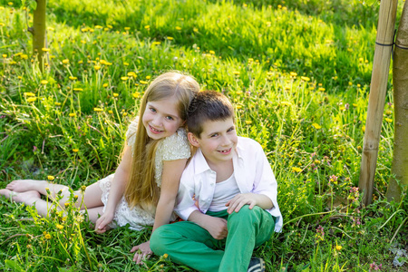 一个男孩和女孩都安放在一个盛开的花园在春天