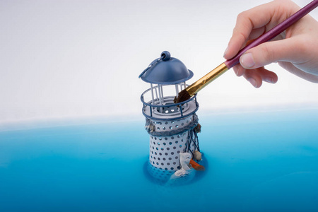 画刷和在水中的小模型灯塔。