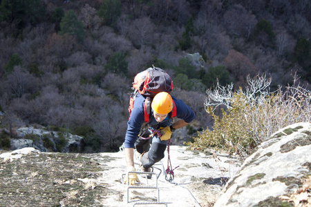 登山者做通过 ferrata 与他的背包里