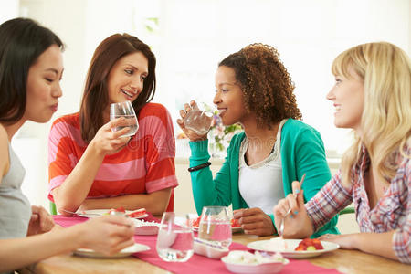 围坐在桌边吃甜点的一群妇女