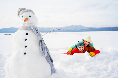 幸福的情侣躺在雪中