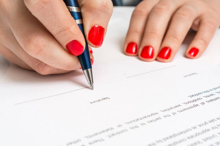 女人用圆珠笔签署合同文档