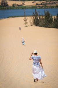 年轻的女性在越南沙漠中行走。 越南梅河白沙沙丘