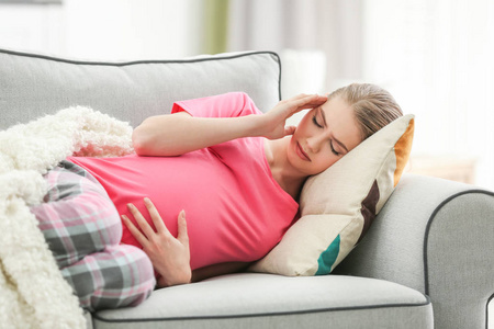 孕妇患头痛躺在家里的沙发上