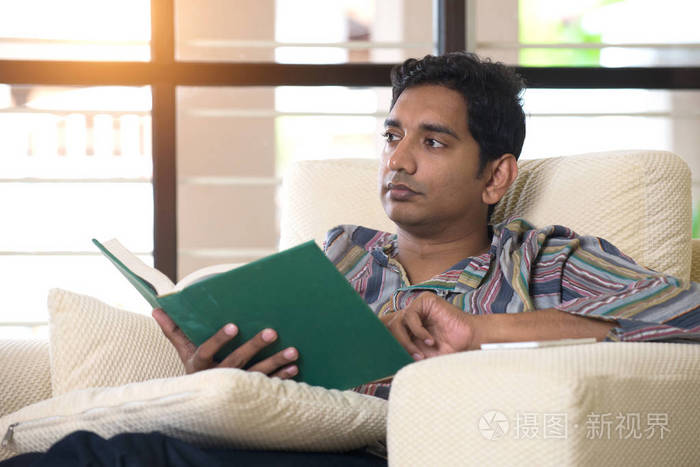 男人坐在沙发上看书