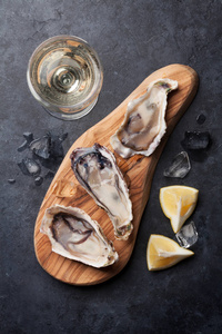 牡蛎在切菜板和白葡萄酒