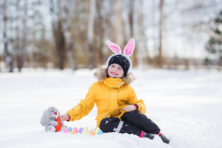 可爱的小女孩兔和篮子坐在沃尔玛的雪