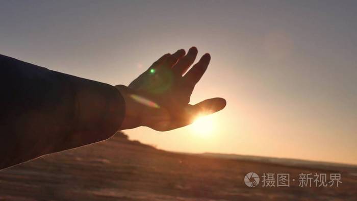 旅行.男人看着阳光透过她手的生活方式旅行