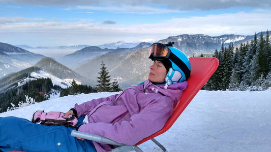 女孩的滑雪者取决于一座雪山边坡