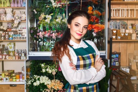 检查她新鲜的花儿的花店小企业主的侧视图