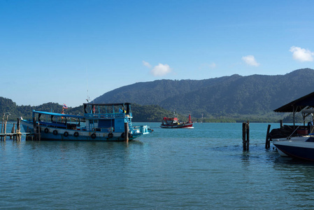 红色和蓝色渔船在海与山背景