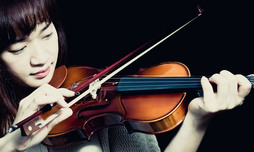 亚洲美丽的女音乐家演奏小提琴图片