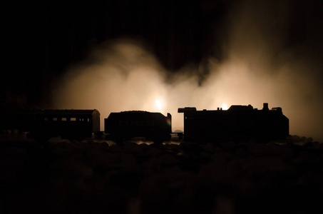 古代蒸汽机车在夜间。夜车在铁路上行驶。橙色的火灾背景。恐怖神秘场景