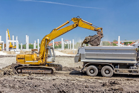 挖掘机加载在建筑工地上的一辆卡车