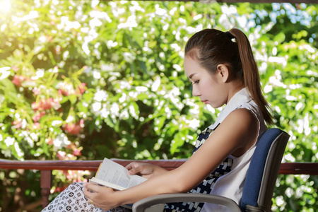 肖像亚洲妇女阅读本书户外放松的时间