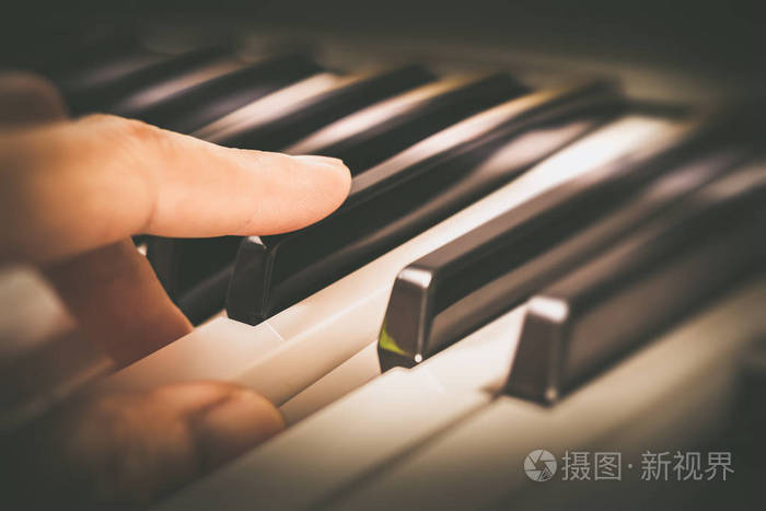男音乐家手指在钢琴键上玩
