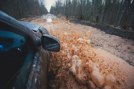 4wd 越野车骑着马穿过泥泞的水坑里，越野轨道路，溅起的水花，在 jeeping 竞争