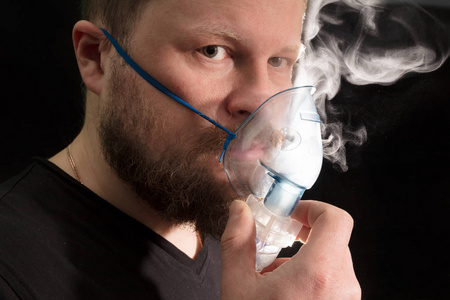 通过雾化器面罩呼吸的人图片