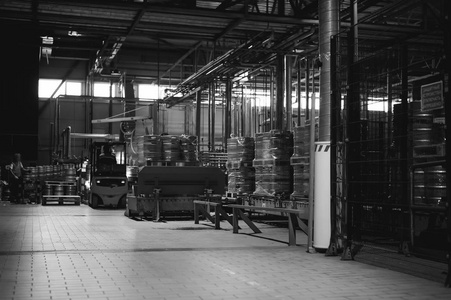 仓库员工工作服的衣服，忙在物流上的 Reachtruck 的驱动程序与上线生产啤酒厂的啤酒桶在装载机托盘上移动。在制造业中的人类