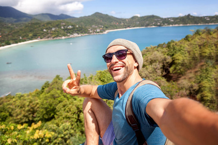 年轻男性时髦旅行做俯瞰 tropica 的自拍照