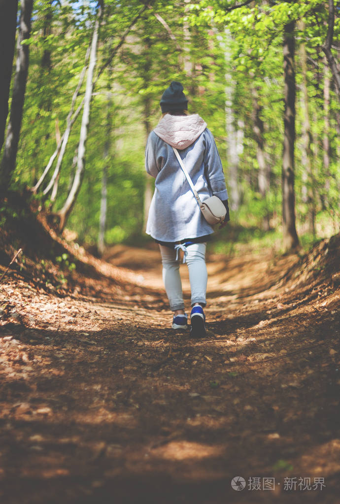 年轻女子独自行走在早春森林