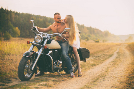 一辆摩托车在字段中的情侣
