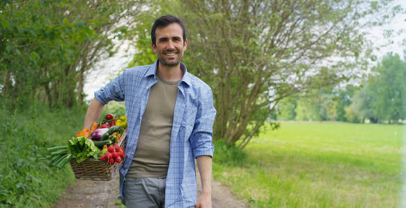 一个快乐的年轻农民，一篮子里拿着新鲜蔬菜的画像。大自然的生物 生物产品 生物生态学，增长了自己的双手，素食主义者，沙拉健康概