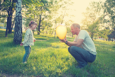 快乐的父亲和微笑的小女儿正在玩颜色