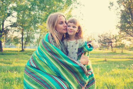 快乐妈妈和小女儿拥抱在公园里