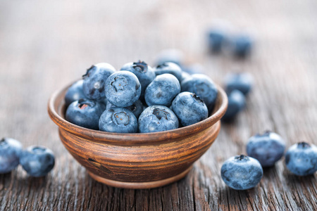 新鲜的蓝莓在碗上木制背景，特写
