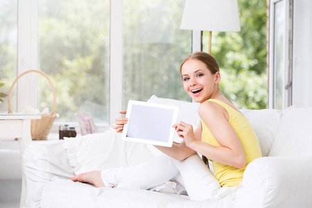 幸福的女人，在客厅里显示电子的平板电脑