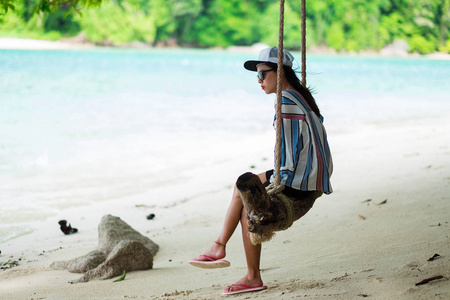 侧面图。亚洲女人穿着夏天的衣服，太阳镜和白色