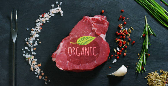 美丽多汁的新鲜肉类牛排上盐 迷迭香 大蒜 番茄在黑色的背景，顶视图的表。概念 新鲜  天然产品 生物产品 肉类产品
