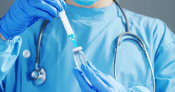医生或科学家在举行一个注射器含有液体疫苗为儿童或老年人，或者治疗动物疾病的实验室。概念 疾病 医疗 科学 麻醉 安乐死