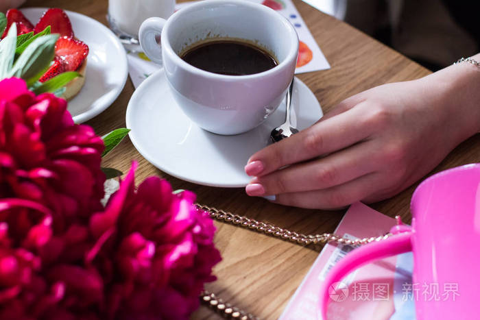 一杯咖啡在一家咖啡馆和一个女孩的手
