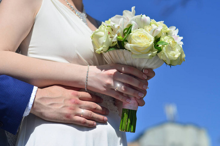 新婚夫妇捧着一束漂亮的婚礼花束。 古典婚纱摄影象征着团结爱和创造新家庭