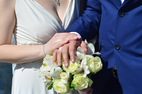 新婚夫妇捧着一束漂亮的婚礼花束。 古典婚纱摄影象征着团结爱和创造新家庭