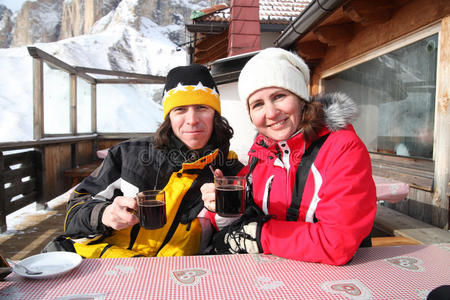 两个滑雪者喝着热葡萄酒