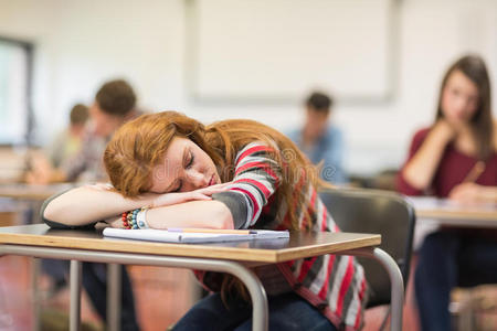 教室里迷离的学生和一个睡着的女孩