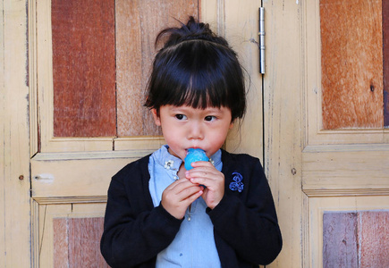 可爱的小女孩，吮棒棒糖。小小的孩子享受她甜甜的美味冰棒